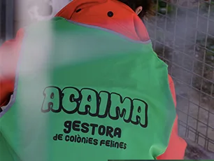 Voluntària d'esquena amb l'armilla verda d'ACAIMA